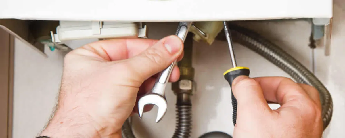 Boiler repair technician tightening pipe fittings and connections in Albuquerque, NM