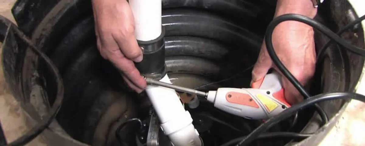 Sump pump installation technician connecting PVC discharge piping in Albuquerque, NM