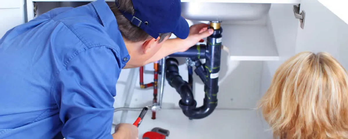 Plumber repairing under-sink drain pipes and fittings in Albuquerque, NM